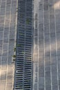 A lattice of a drainage paving system on a footpath made of square stone tiles, close up of a rainwater drainage system Royalty Free Stock Photo