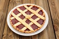 Lattice round cake with strawberry jam on wooden background Royalty Free Stock Photo