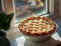 lattice-top apple pie, windowsill, sunlight, rustic decor, warm ambiance Royalty Free Stock Photo