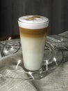 Latto macchiato coffee in a glass beaker against