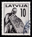 LATVIA - CIRCA 1992: A stamp printed in Latvia shows Ancient Warrior, fragment of the Brethren Cemetery, circa 1992. Royalty Free Stock Photo