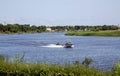 Motor boat rides of people on inflatable sofa down the Lielupe river Royalty Free Stock Photo