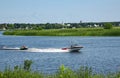 Motor boat rides of people on inflatable sofa down the Lielupe river Royalty Free Stock Photo