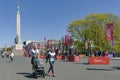 Dancers in Latvian national costumes stand on special platforms and meet running people at the Rimi Riga Marathon 2023.