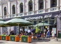 People have lunch on the summer veranda of McDonalds cafe in Riga Royalty Free Stock Photo