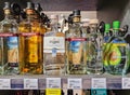 Rows different glass bottles of vodka on shelves in supermarket for sale.