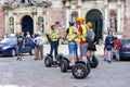 Tourists stand of electric scooters Segway and listen to the guide story in Riga Old Town