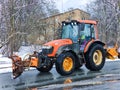 Snow plow tractor outdoors cleaning pavement and road in Riga Royalty Free Stock Photo