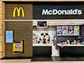 McDonalds counter with menu of different fast food snacks and cash desk in Riga