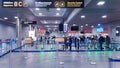Passengers go to checkpoint in hall with flights information in Riga international airport