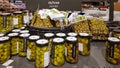 Canned green olives in a glass jars and vacuum packaging on shelves