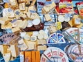 A large selection of cheeses with different types, textures and flavors in a grocery showcase