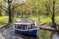 Pleasure boat with tourists cruise along the Riga river canal near Kronvalda park Royalty Free Stock Photo