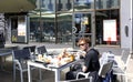 A young man has lunch on the open veranda of a McDonalds cafe in Riga Old Town Royalty Free Stock Photo