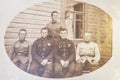 Latvia - 1930s: An antique photo shows five soldiers posing in front of wooden house