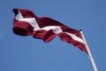 Latvian flag in the blue sky