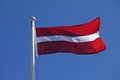 Latvian flag waving in the wind on a blue summer sky Royalty Free Stock Photo