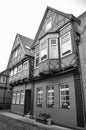 Black and white photo from a historical cobblestone alley with half-timbered houses