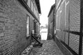 Black and white photo from a historical cobblestone alley with half-timbered houses to the Elbe river