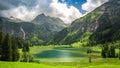 Lauenensee with waterfall and Swiss Alps in the background, Switzerland.