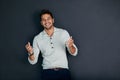 Laugh, and the whole world laughs with you. Studio shot of a handsome young man against a dark background. Royalty Free Stock Photo