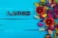Laugh word on blue wood with flower