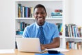 Laughing african american businessman with necktie at computer