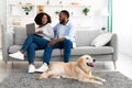 Black couple at home using pc relaxing with dog Royalty Free Stock Photo