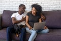 Laughing African American couple using laptop together at home Royalty Free Stock Photo