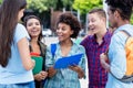 Laughing african american exchange student talking with latin and hispanic young adults Royalty Free Stock Photo