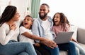 Laughing african american family using laptop in living room Royalty Free Stock Photo