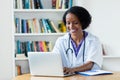 Laughing african american female doctor working on computer Royalty Free Stock Photo