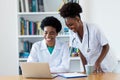 Laughing african american female doctor with young nurse
