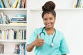 Laughing african american female nurse or medical student showing thumb up Royalty Free Stock Photo