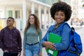 Laughing african american female student with backpack and group of international students Royalty Free Stock Photo