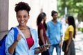 Laughing african american female student with tablet computer and group of young adults Royalty Free Stock Photo