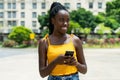 Laughing african american girl with phone sending message Royalty Free Stock Photo