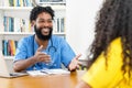 Laughing african american male nurse talking with female patient Royalty Free Stock Photo