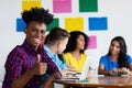 Laughing african american male student at computer with group of students Royalty Free Stock Photo