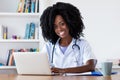 Laughing african american nurse or medical student at computer