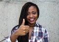 Laughing african american woman with dreadlocks showing thumb up Royalty Free Stock Photo