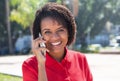 Laughing african american woman talking at mobile phone in city Royalty Free Stock Photo