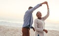 Laughing African couple dancing together on a beach at sunset Royalty Free Stock Photo
