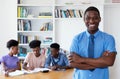 Laughing african male teacher with class at school