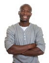 Laughing african man in a grey shirt with crossed arms Royalty Free Stock Photo