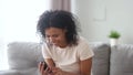 Laughing african woman holding smartphone read anecdote feels overjoyed