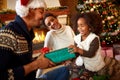 Laughing afro American family exchanging gifts for Christmas Royalty Free Stock Photo