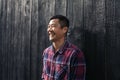 Laughing Asian man leaning against a wall in the city Royalty Free Stock Photo