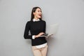 Laughing asian woman in business clothes using laptop computer Royalty Free Stock Photo