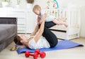 Happy laughing baby boy exercising with mother on yoga mat at home Royalty Free Stock Photo